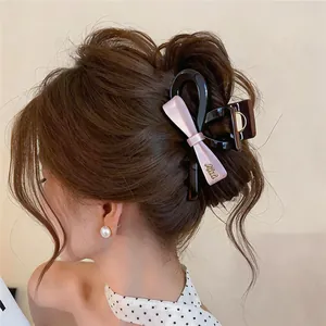 Détail d'une pince à cheveux de style coréen en acrylique avec nœud rose sur cheveux