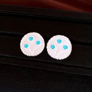 Nahaufnahme minimalistischer runder Vintage-Silberohrringe mit blauen Harzblumenmotiven