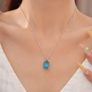 Elegant silver chain necklace with a brilliant blue oval zircon pendant close-up