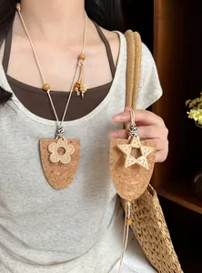 Detailansicht der handgefertigten Kork-Brillenclip-Halsketten mit Blumen- und Sternenmuster.