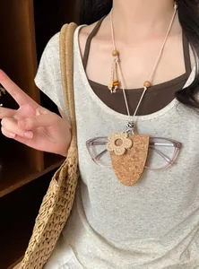 Detailansicht einer Brillenkette aus Kork mit gewebter Blumendekoration an einem Modell