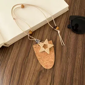 Nahaufnahme der Boho-Leder-Brillenhalterkette mit gewebtem Stern und Korkanhänger