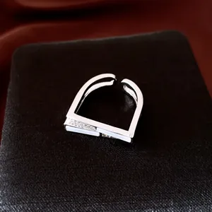 Détail d'une bague ouverte carrée en argent moderne sertie de zircons blancs