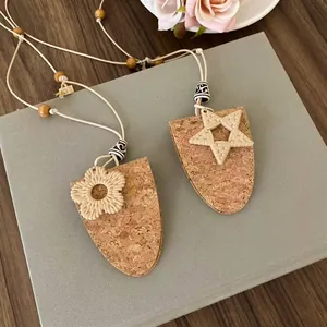Detailansicht von Kork-Schildanhängern mit handgewebten Blumen- und Sternmotiven für Damen.