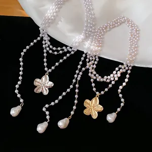 Élégant collier de perles multicouches avec un pendentif en forme de fleur dorée