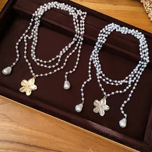 Vue détaillée de colliers de perles multicouches dorés et argentés avec fleurs
