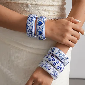 Close-up of blue and white porcelain style resin bangles with floral and heart patterns