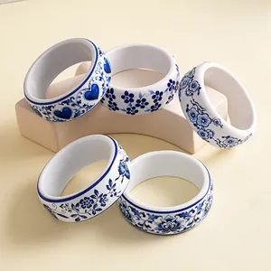 Close-up of blue and white porcelain style resin bangles with heart and floral patterns