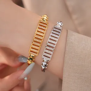Nahaufnahme von Gold- und Silberarmreifen mit Zirkonia-Pavé und dekorativen Nieten