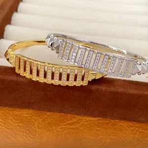 Elegante gold- und silberfarbene Zirkonia-Armreifen mit rechteckigem Durchbruchmuster