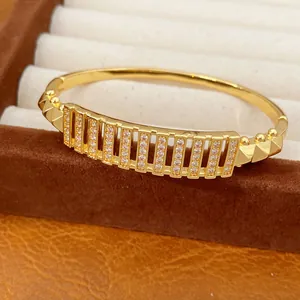 Luxuriöser goldfarbener Hohlarmreif mit funkelnden Zirkonsteinen für modebewusste Damen