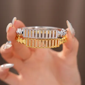 Detailansicht von zwei mit Zirkon besetzten Hohlarmbändern in Gold- und Silberschliff