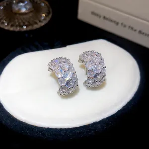 Detail view of sparkling cubic zirconia C-shaped ear studs with a luxury silver-tone finish
