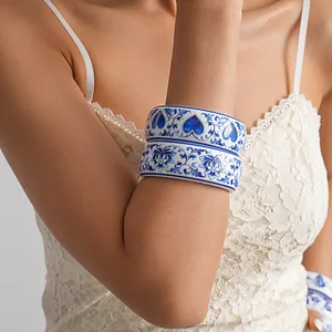 Detailed view of resin bangles with blue and white porcelain floral and heart prints