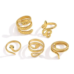 Gedetailleerd overzicht van vijf gouden slangenvormige ringen met sprankelende zirkoon.