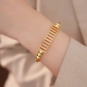 Detailaufnahme eines vergoldeten Armbands mit Zirkonia-Besatz und Hohlstruktur.