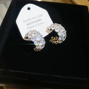Macro detail of sparkling zircon C-shaped earrings with S925 silver tag