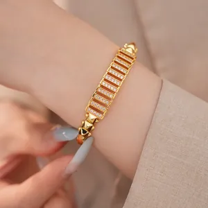 Nahaufnahme eines vergoldeten Armreifs mit Zirkonia-Pavé und Pyramidennieten
