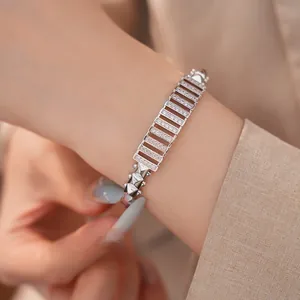 Detailansicht eines eleganten Silberarmbands mit Zirkonia-Pavé auf dem Handgelenk eines Models