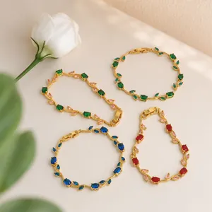 Detailansicht von vier bunten Rankenblatt-Armbändern in Goldoptik mit Kristallakzenten