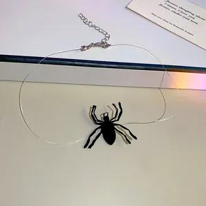 Macro view of a dark Halloween spider choker with a transparent cord and adjustable chain.