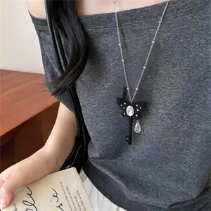 Detail van een zwarte vlindersleutel ketting met sprankelende kristallen.