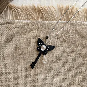 Detailweergave van een zwarte vlindersleutelketting in Franse stijl met fonkelende strass