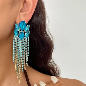 Detailansicht luxuriöser blauer Kristallohrringe mit langen glitzernden Quasten am Model