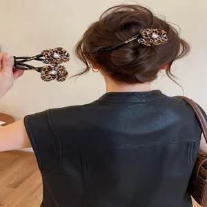 Detailed view of leopard print flower hair clip in a styled bun