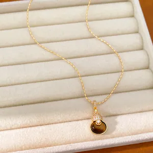 Detail van 18k vergulde kalebas hanger ketting met tijgeroog steen en zirkonia's.