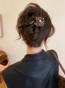 Elegant leopard print flower hair clip shown in a stylish twisted hair bun detail