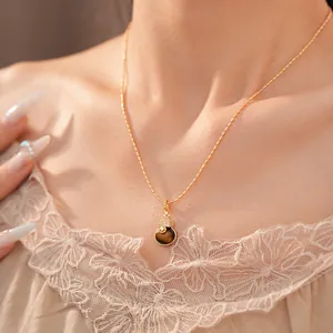 Gedetailleerd beeld van een 18k vergulde kalebas ketting met tijgeroog steen en zirkoon.