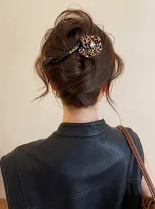 Detailed macro shot of a leopard print flower hair clip styled in a classic updo