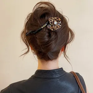 Detailed macro view of a leopard print flower hair twist clip on an elegant bun updo