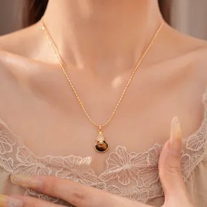 Detailopname van een elegante tijgeroogsteen kalebas hanger ketting met 18k goud verguld