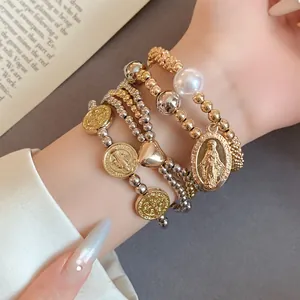 Close-up of 4pcs beaded bracelet set with heart, pearl, and religious coin charms