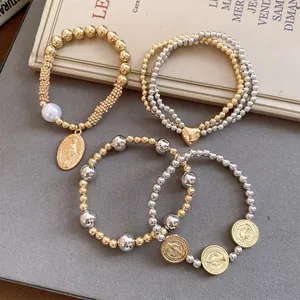 Detail view of 4pcs elastic beaded bracelets with heart and religious coin charms.