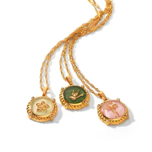 Close-up of enamel round pendant necklaces featuring flower, bird, and bow motifs