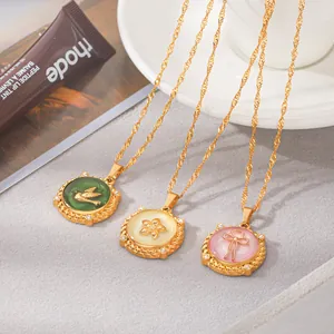 Detail showing three gold-tone necklaces with green, white, and pink enamel pendants.