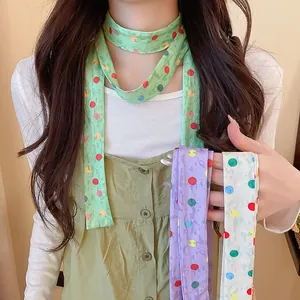 Detailaufnahme von bunten gepunkteten schmalen Schals aus grünem, lila und cremefarbenem Polyester.