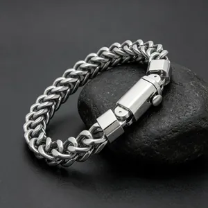 Macro detail of a silver stainless steel Franco chain bracelet with square press clasp.