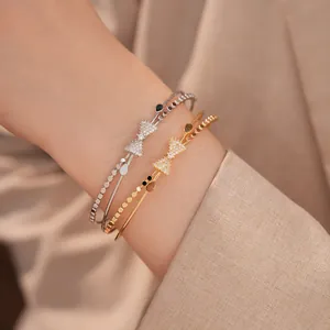 Nahaufnahme der zweilagigen Schleifen-Armreifen mit Zirkonia in Gold und Silber