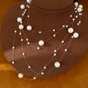 Détail élégant d'un collier de perles blanches multicouche avec des fils transparents