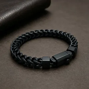 Detailed close-up of a masculine black stainless steel wheat chain bracelet with a square clasp