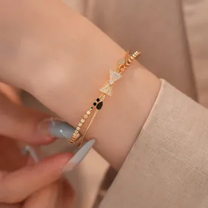 Elegante Detailaufnahme eines goldenen zweilagigen Schleifenarmbands mit Zirkonia