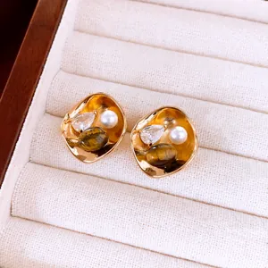 Gros plan de boucles d'oreilles vintage en plaqué or 18k avec perle, zircon et pierre d'œil