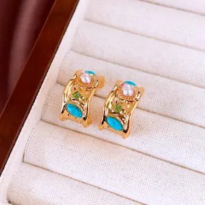 Gros plan de boucles d'oreilles vintage plaquées or 18k avec perles et turquoises