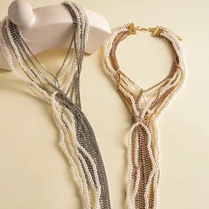 Primo piano di collane con nappe di perle e strass vintage su sfondo crema