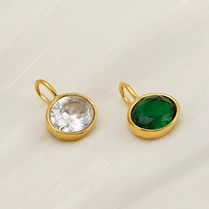Détail macro de pendentifs ovales en émeraude et cristal sur tissu en soie blanche
