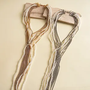 Dettaglio di collane multistrato vintage con perle e strass nei colori oro e argento